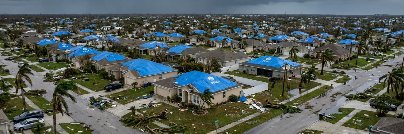Aerial view of Florida neighborhood with FEMA blue tarps on every roof after hurricane