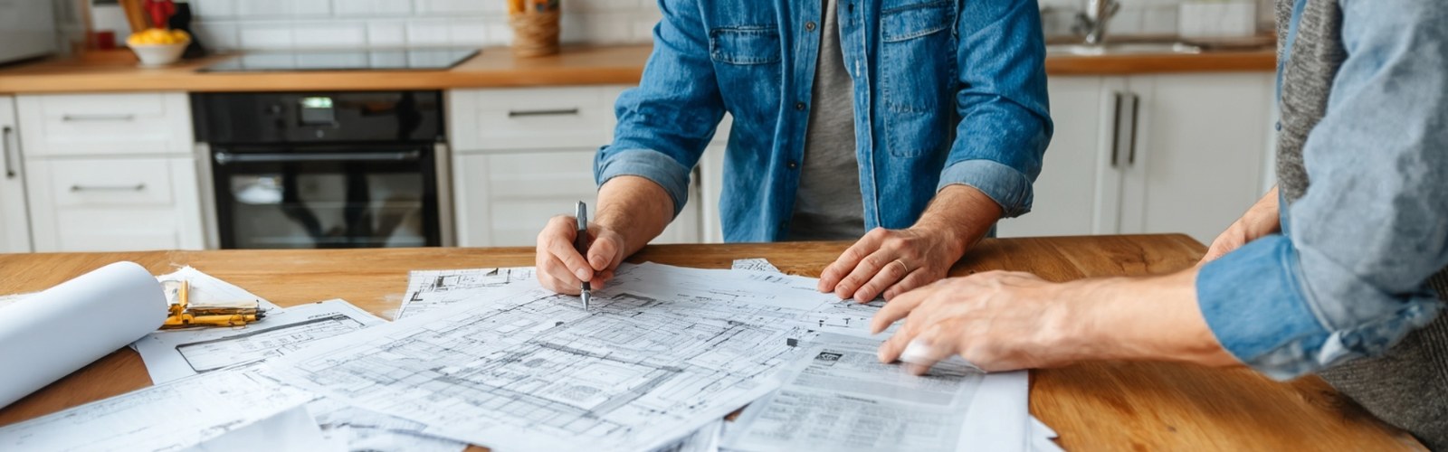 Two contractors reviewing shutter installation blueprints and contract at table