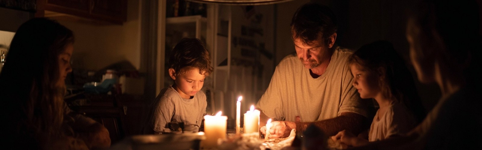 Family using candles during a hurricane power outage at night